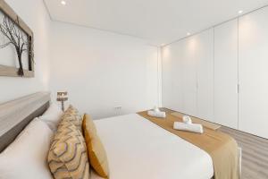 un dormitorio con una cama con dos almohadas. en Consolação Breeze Apartment, en Atouguia da Baleia