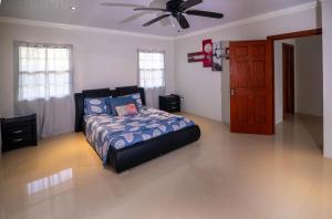 a bedroom with a bed and a ceiling fan at Ti Anglete Villa in Soufrière