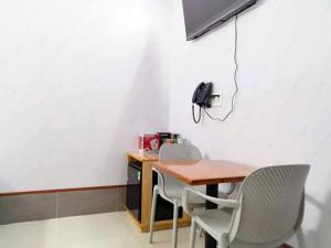a desk with two chairs and a phone on a wall at Vinh Hotel in Thốt Nốt
