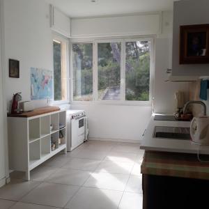 a kitchen with white appliances and a large window at Villa Nicole avec Spa professionnel in Carry-le-Rouet