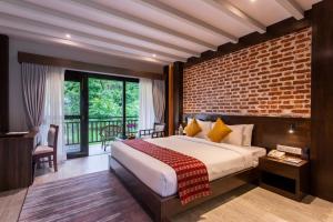 Letto o letti in una camera di Regenta Resort & Spa By Riverside, Chitwan