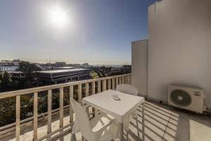 a white table and chairs on a balcony with a train at Hotel Alvorada in Estoril
