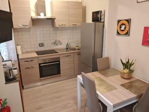 a kitchen with a table and a stainless steel refrigerator at La Casetta di Alex in Ventimiglia
