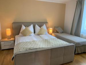 a bedroom with two beds with pillows and two lamps at Dorfappartements ALLEE 11 in Puchberg am Schneeberg