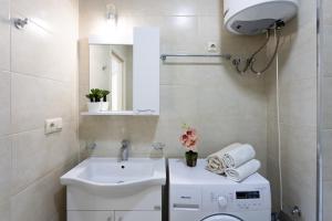 a bathroom with a sink and a washing machine at Cozy place New Boulevard in Batumi +20 photos
