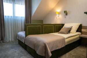 a bedroom with a bed with a green headboard at AURORA Tarnów in Tarnów