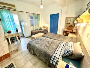 a bedroom with a bed and a living room at Seafront Stories of Samos in Votsalákia