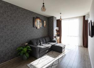 a living room with a couch and a window at Cozy place New Boulevard in Batumi