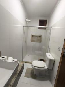 Un baño con inodoro, ducha y lavabo. en Vila Bahia suítes, en Caraíva