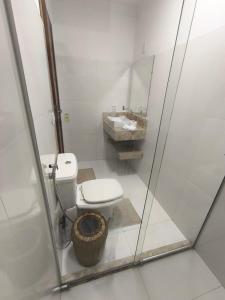 un baño con inodoro y lavabo en Vila Bahia suítes, en Caraíva