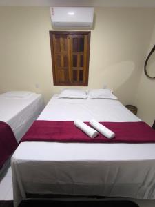 2 toallas blancas en una cama en una habitación en Vila Bahia suítes, en Caraíva