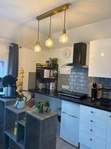 a kitchen with white cabinets and a black counter top at Preston Room Let in Yeovil
