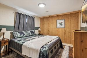 a bedroom with a bed and a wooden wall at Stone Haven By Beyond Expectations W Hot Tub in Sevierville