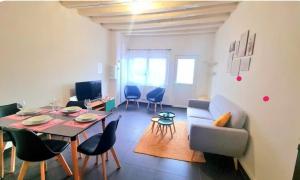 a living room with a table and chairs and a couch at Cœur de Ville - familial - Parking gratuit - WIFI in Conches-en-Ouche