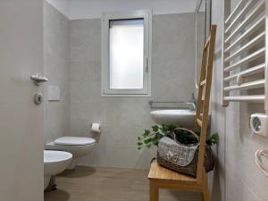 a bathroom with a toilet and a sink and a window at VINCI - Narramondo Villas in Tortoreto Lido