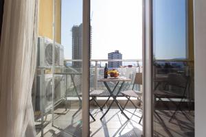 a balcony with a table and chairs on a balcony at Cozy place New Boulevard in Batumi