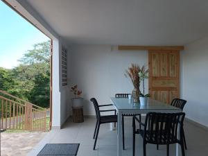a dining room with a table and chairs on a patio at Maison de vacances à Deshaies 971 in Deshaies