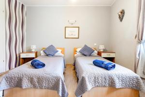 two beds in a room with blue pillows on them at Old Stone House with private Swimming Pool in Solin +44 photos