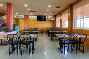 a dining room with tables and chairs and a tv at Hotel Restaurant Casa Miquel in Alcarraz