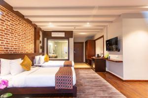 Letto o letti in una camera di Regenta Resort & Spa By Riverside, Chitwan