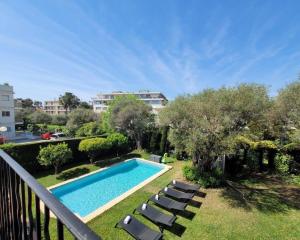 balkon z basenem i krzesłami w obiekcie Juan les pins : Villa de charme avec piscine w mieście Juan-les-Pins