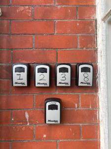 a brick wall with a bunch of clocks on it at Preston Room Let in Yeovil