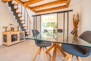 una sala da pranzo con tavolo e sedie in vetro di La villa de Mara a Canet-en-Roussillon Altre 13 foto