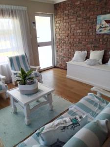 una sala de estar con un sofá y una mesa en Geelstert 25, en Struisbaai