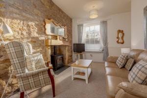 a living room with a couch and a stone wall at Fleming Place Haven in St. Andrews