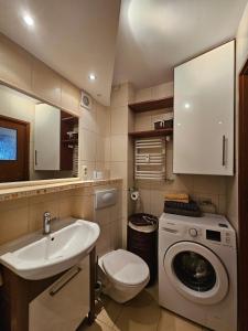 a bathroom with a sink and a washing machine at GLAMOUR Apartment in Poznań