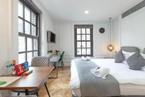 a bedroom with a bed and a table and a desk at London Paddington Apartments in London
