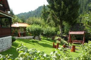 a garden with a tree and a gazebo at Uni-kom forest lodge in Lacu Rosu