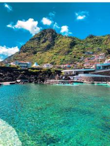 a body of water with a mountain in the background at Village Sun House - Porto Moniz in Porto Moniz