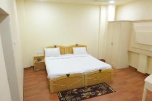 a bedroom with a bed with white sheets and pillows at Vibha Raj Grand in Kānpur +113 photos