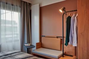 a bedroom with a bed and a chair and a window at Aparthotel Adagio London City East in London