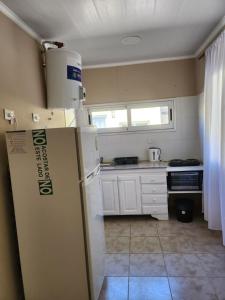 a small kitchen with a refrigerator and a stove at Complejo Génesis in San José