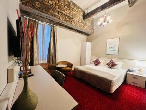 a hotel room with a bed and a desk with a tv at Aria Palace Taksim & Spa in Istanbul +86 photos