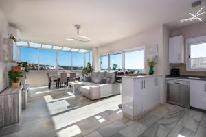 a kitchen and living room with a couch and a table at Stunning Beachfront Penthouse in Estepona