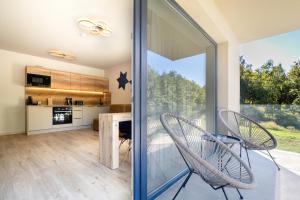 a kitchen and dining room with a sliding glass door at Optimus Residence in Balatonföldvár