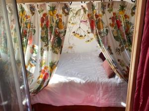 a small bed in a room with curtains at Insolite in Villersérine