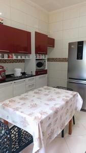 a kitchen with a table with a floral table cloth on it at Quarto Privativo Santa Rita do Sapucaí in Santa Rita do Sapucaí