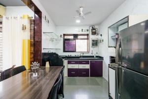 a kitchen with a table and a refrigerator at ZenStays - Premium Service Apartment in Mulund West in Mumbai