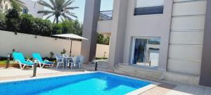 Casa con piscina, mesa y sillas en VILLA midoun, en Taguermess