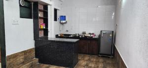 a kitchen with a black counter and a refrigerator at Gotawala Villa 11 in Daman