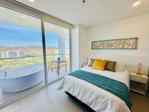 a bedroom with a bed and a tub and a balcony at U-GO Porto Horizonte: Escapada Frente al Mar en Santa Marta in Taganga +32 photos