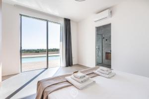 een witte slaapkamer met een bed en een groot raam bij Villa Valentina in Pula