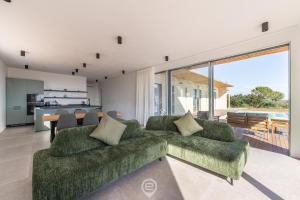 een woonkamer met een groene bank en een keuken bij Villa Valentina in Pula