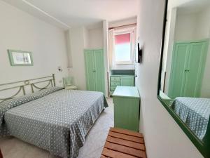 a bedroom with two beds and green cabinets and a window at Hotel Dania in Sorrento