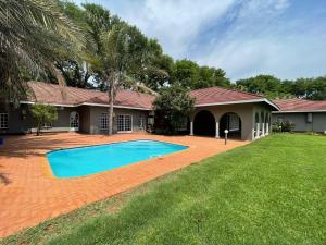 a house with a swimming pool in the yard at Riecor Guest Farm in Thabazimbi