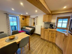 a kitchen and living room with a table and a couch at Bergbauernhof Klauslehen in Ramsau